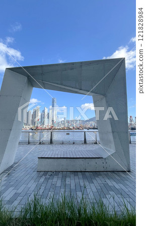 Hong Kong Victoria Harbour with cityscape, ships, textured floor and fixture in outdoor park 121828984