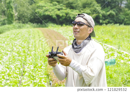 A male farmer piloting a drone A male farmer piloting a drone 121829532