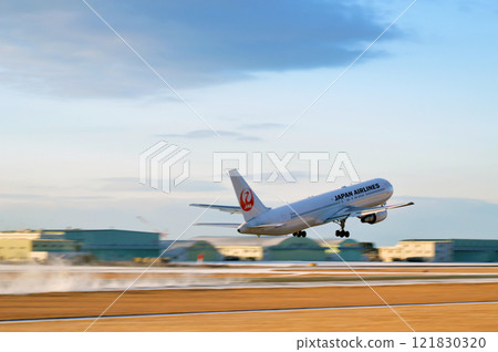 A passenger plane takes off, raising a cloud of snow 121830320