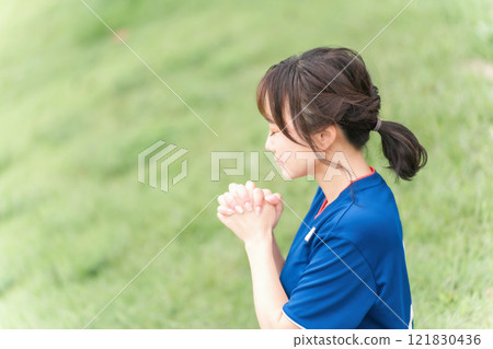 一位日本女性,她是一名足球迷和支持者,為日本國家隊歡呼,彷彿在祈禱 一位日本女性,她是一名足球迷和支持者,為日本國家隊歡呼,彷彿在祈禱 121830436