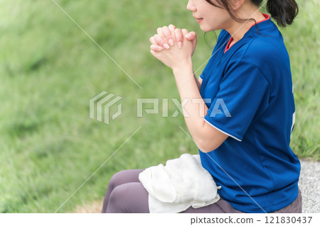 A Japanese woman who is a soccer fan and supporter cheering for the Japan national team as if praying A Japanese woman who is a soccer fan and supporter cheering for the Japan national team as if praying 121830437