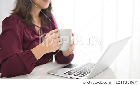 中間女性觀看個人計算機在客廳 121830867