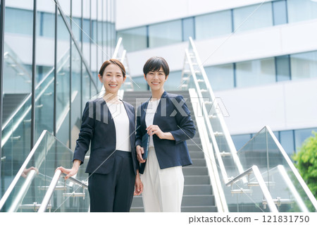 一個穿著西裝的女人在辦公室的樓梯上微笑 121831750