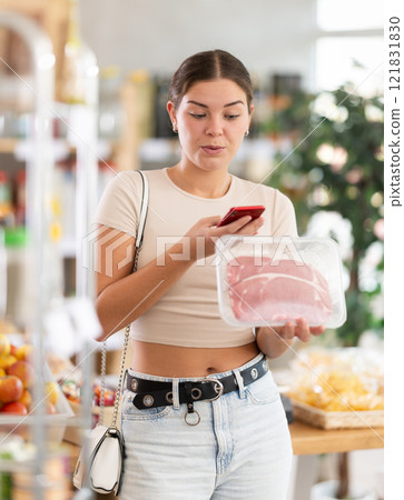 Young woman scanning qr code of raw entrecote Young woman scanning qr code of raw entrecote 121831830