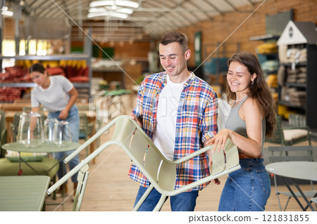 Spouses buyer choose chair in garden furniture store showroom 121831855