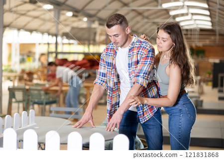 Spouses buyer choose table desk in garden furniture store showroom Spouses buyer choose table desk in garden furniture store showroom 121831868