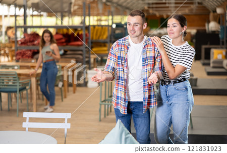 Cheerful couple browsing in home and garden furniture store 121831923