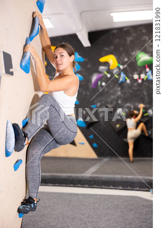 Young woman practicing rock climbing on climbing wall Young woman practicing rock climbing on climbing wall 121831990