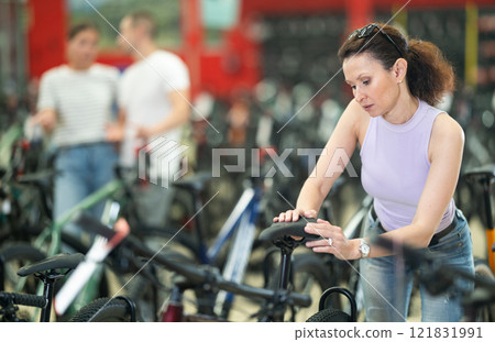 Adult woman choosing bike in store 121831991