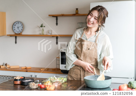 Young Asian woman (mother, wife, housewife) preparing lunch in the kitchen Young Asian woman (mother, wife, housewife) preparing lunch in the kitchen 121832056