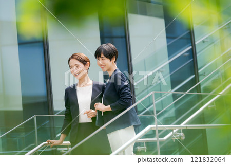 兩個女人從辦公室的樓梯上下來 121832064