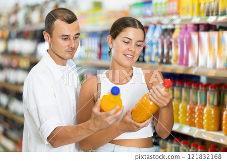 Married couple in supermarket buys bottle of soda drink 121832168