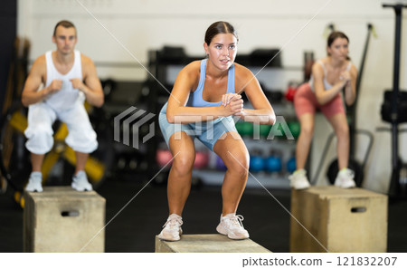 Young woman training with crossfit box 121832207