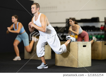 Athletic man in sportswear training his legs in gym 121832254