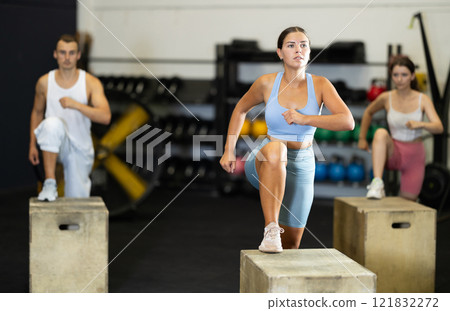 Woman doing muscle stretching. CrossFit in a group with other athletes 121832272