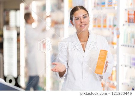 Young female pharmacist offering preparation in box Young female pharmacist offering preparation in box 121833449
