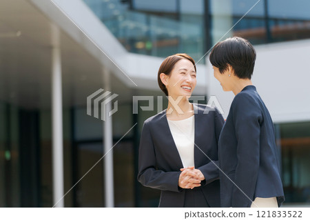 two businesswomen chatting two businesswomen chatting 121833522