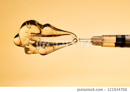A drop of gel pours from a syringe for cosmetic procedures. A drop of gel pours from a syringe for cosmetic procedures. 121834708