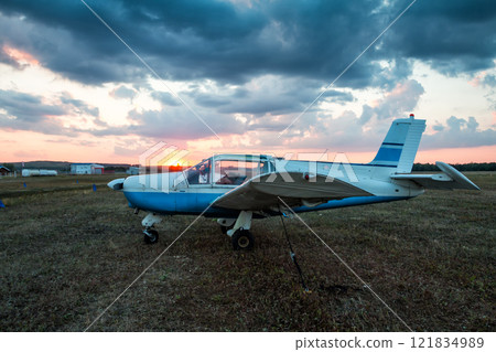 Small private aircraft parked at the airfield at picturesque sunset Small private aircraft parked at the airfield at picturesque sunset 121834989