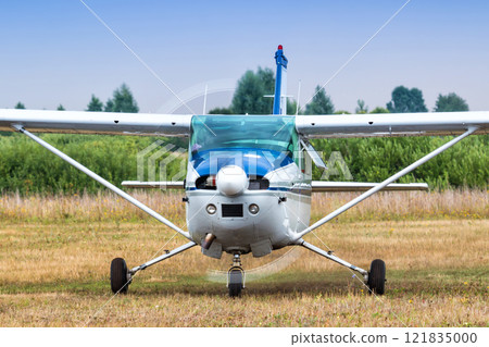 Front view of the small private aircraft with the engine running at the airfield 121835000