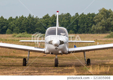 Front view of the private single-engined piston-powered airplane taxiing at the airfield 121835008