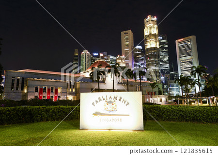Night view of the Singapore Parliament House, which is a public building and a cultural landmark on the bank of the Singapore River, with a background of Financial District skyscrapers. 121835615