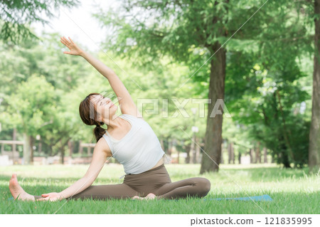 A female yoga instructor doing yoga, yoga class, pilates in the park or forest A female yoga instructor doing yoga, yoga class, pilates in the park or forest 121835995