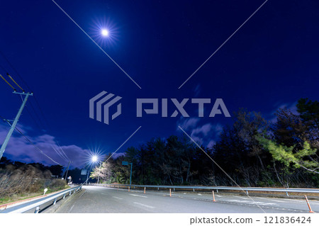 A silent road illuminated by moonlight 121836424