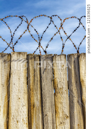 Barbed wire on the fence 121836825