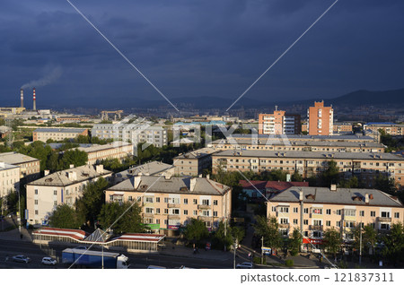 The city of Ulan-Ude is brightly illuminated by the setting sun under a dark thundercloud The city of Ulan-Ude is brightly illuminated by the setting sun under a dark thundercloud 121837311