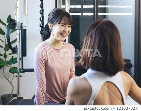 一位女士在健身房接受教練的諮詢 121837327