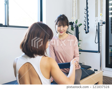 一位女士在健身房接受教練的諮詢 121837328