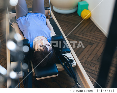 Woman doing machine pilates training 121837341