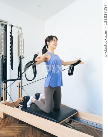 Woman doing machine pilates training 121837357