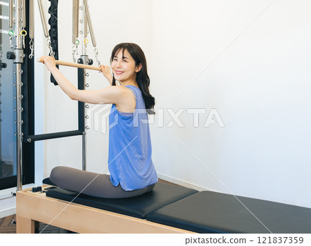 Woman doing machine pilates training 121837359