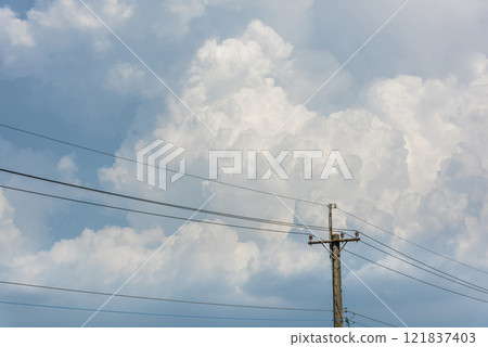 View of utility poles with blue sky and white clouds as a background. View of utility poles with blue sky and white clouds as a background. 121837403
