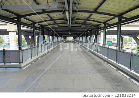 Pedestrian pathway or corridor or hallway between train station and other building. Pedestrian pathway or corridor or hallway between train station and other building. 121838214