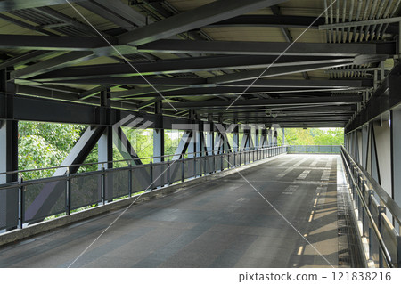 Pedestrian pathway or corridor or hallway between train station and other building. 121838216