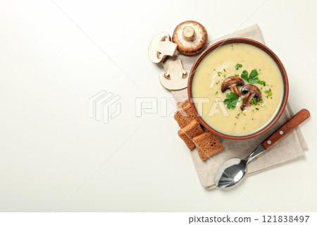A bowl of cream of mushroom soup with parsley and croutons 121838497