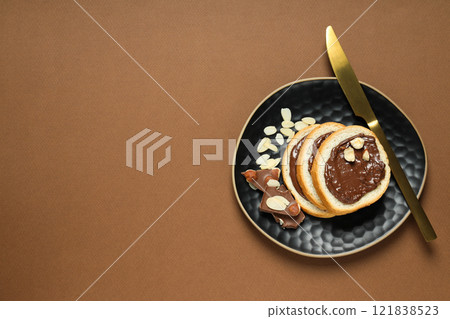 Bread with chocolate paste in a bowl on a brown background 121838523