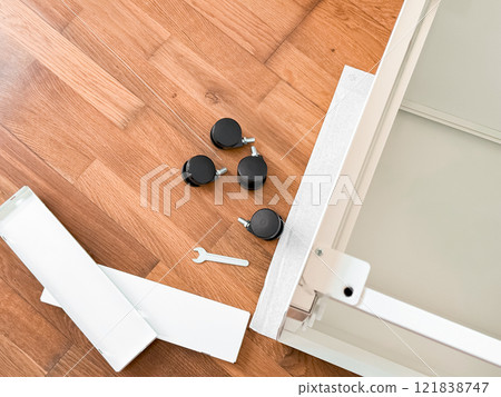 Furniture assembly with wheels on hardwood floor 121838747