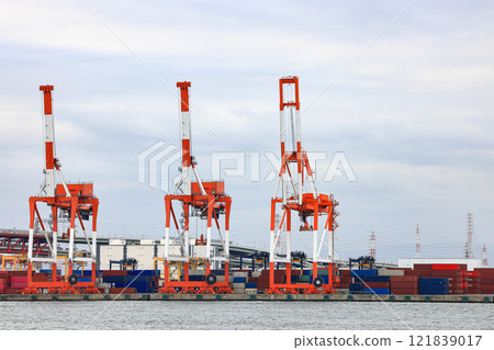 Container port at Osaka Japan, container crane at Industrial port for cargo container ship. Cargo transportation and activity at modern shipping container terminal. Container port at Osaka Japan, container crane at Industrial port for cargo container ship. Cargo transportation and activity at modern shipping container terminal. 121839017