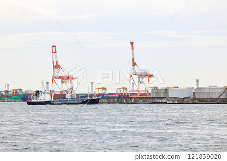 Container port at Osaka Japan, container crane at Industrial port for cargo container ship. Cargo transportation and activity at modern shipping container terminal. Container port at Osaka Japan, container crane at Industrial port for cargo container ship. Cargo transportation and activity at modern shipping container terminal. 121839020