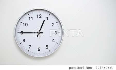 Minimalist White Clock with Silver Frame Striking 12.45/00.45 on White Background. Perfect for Time Management and Corporate Campaigns 121839350