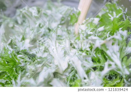 Mixing wasabi leaves with mayonnaise (stock photo) Mixing wasabi leaves with mayonnaise (stock photo) 121839424