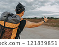Man tourist backpacker hitchhike for pickup on the local country road. 121839851