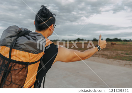 Man tourist backpacker hitchhike for pickup on the local country road. Man tourist backpacker hitchhike for pickup on the local country road. 121839851