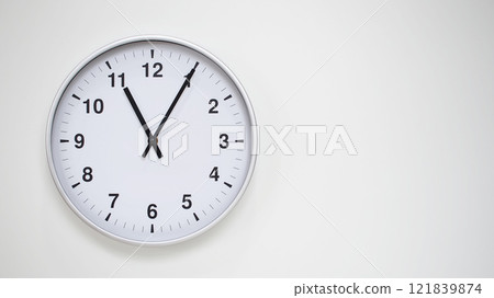 Minimalist White Clock with Silver Frame Striking 23.05/11.05 on White Background. Perfect for Time Management and Corporate Campaigns 121839874