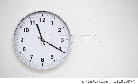 Minimalist White Clock with Silver Frame Striking 11.20/23.20 on White Background. Perfect for Time Management and Corporate Campaigns 121839877