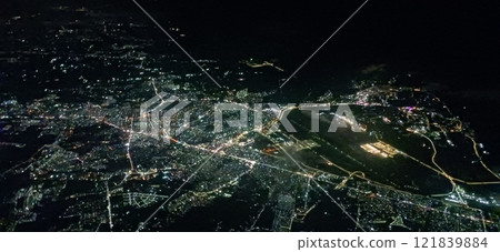 Aerial view of the city at night: shining city lights and a tranquil sea 121839884